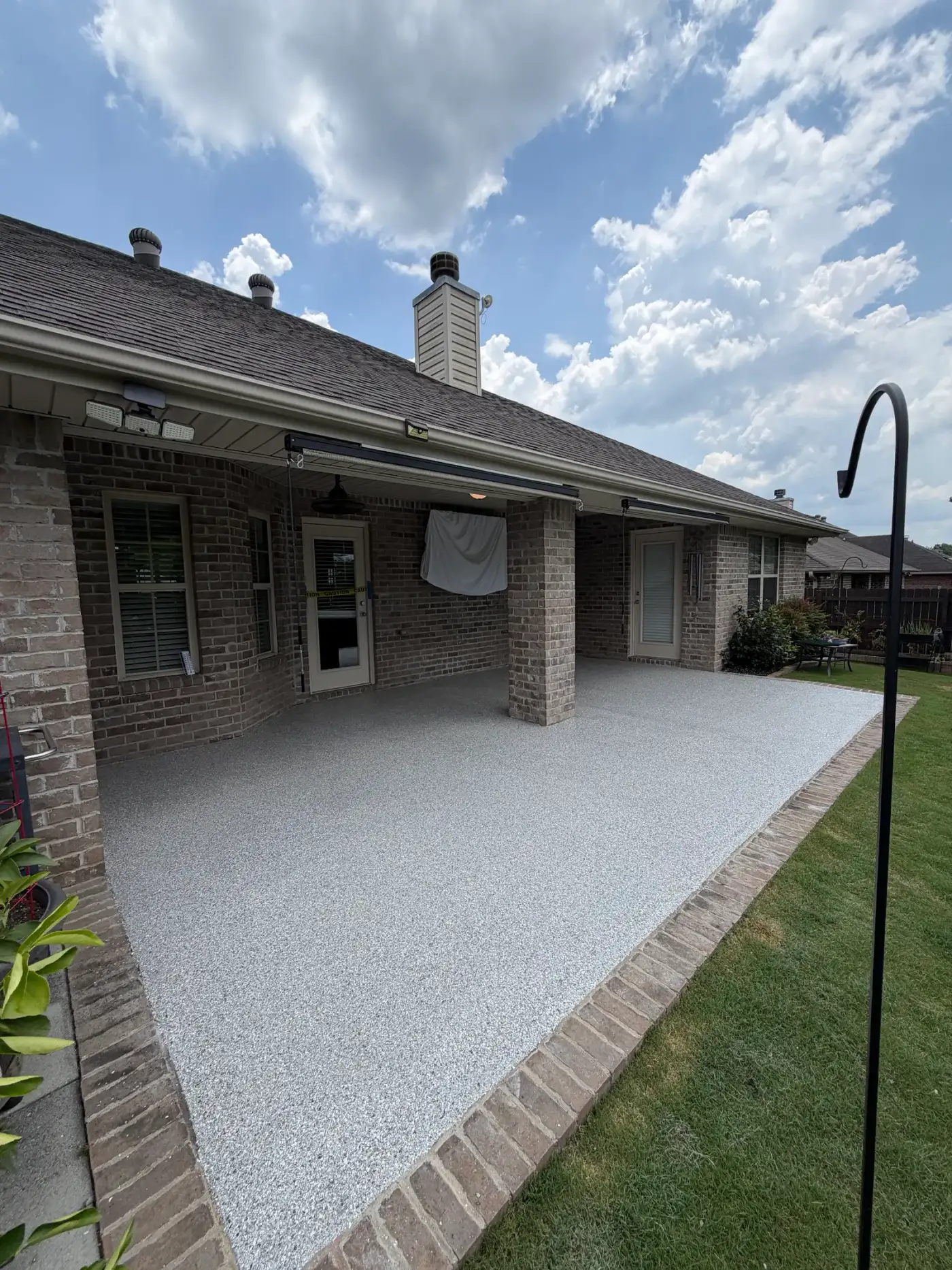 Curved back patio of a brick home with a light flake slip-textured coating