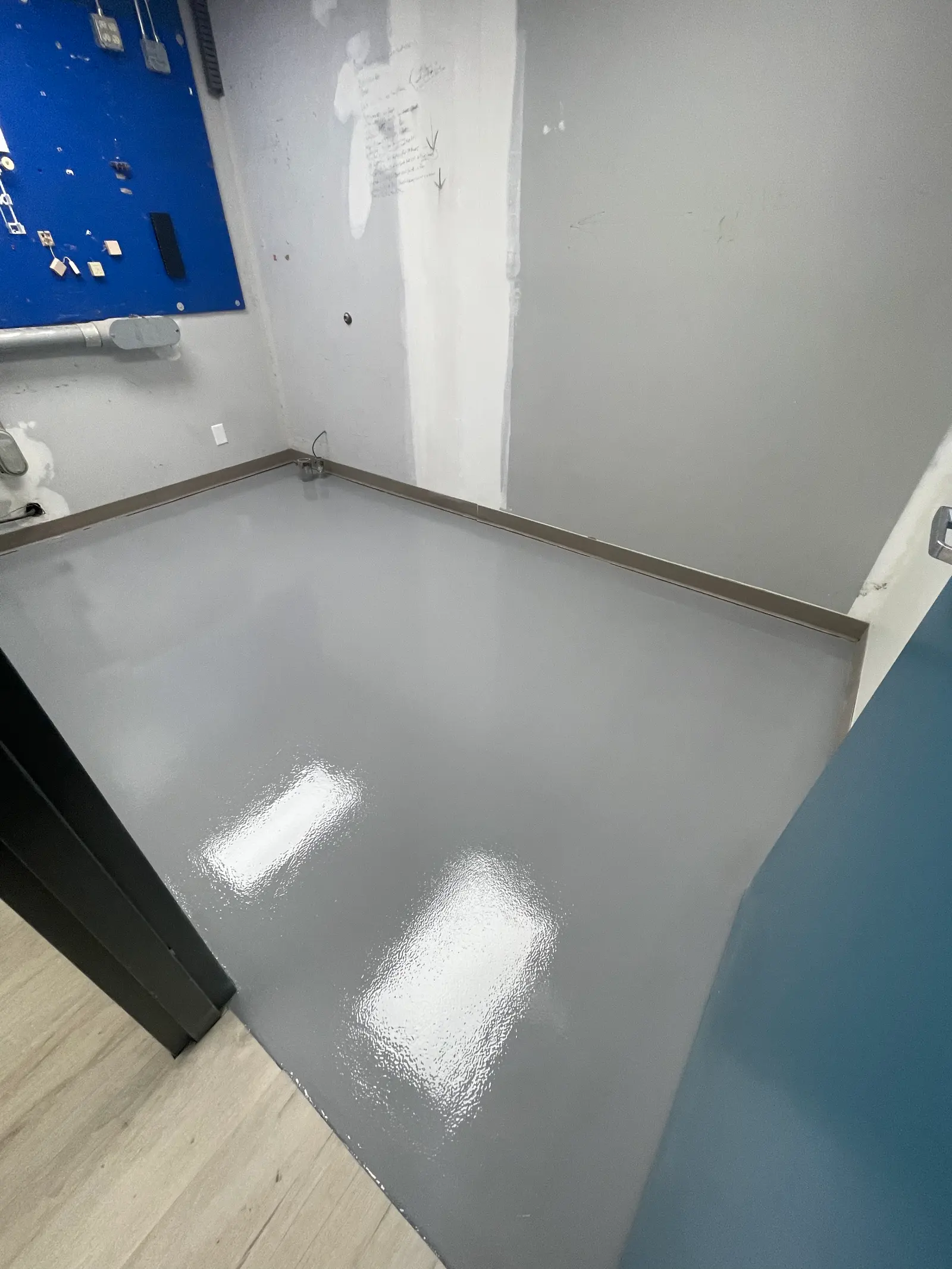 Commercial back-of-house room with a freshly rolled solid gray epoxy floor