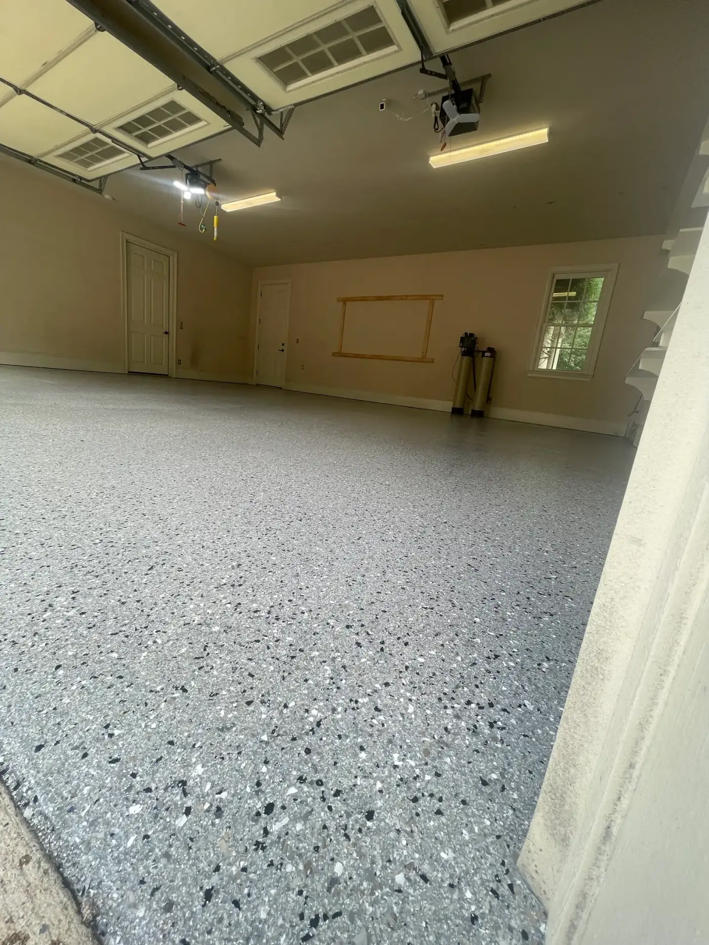 Garage with a blue-gray flake floor meeting a bare exterior apron