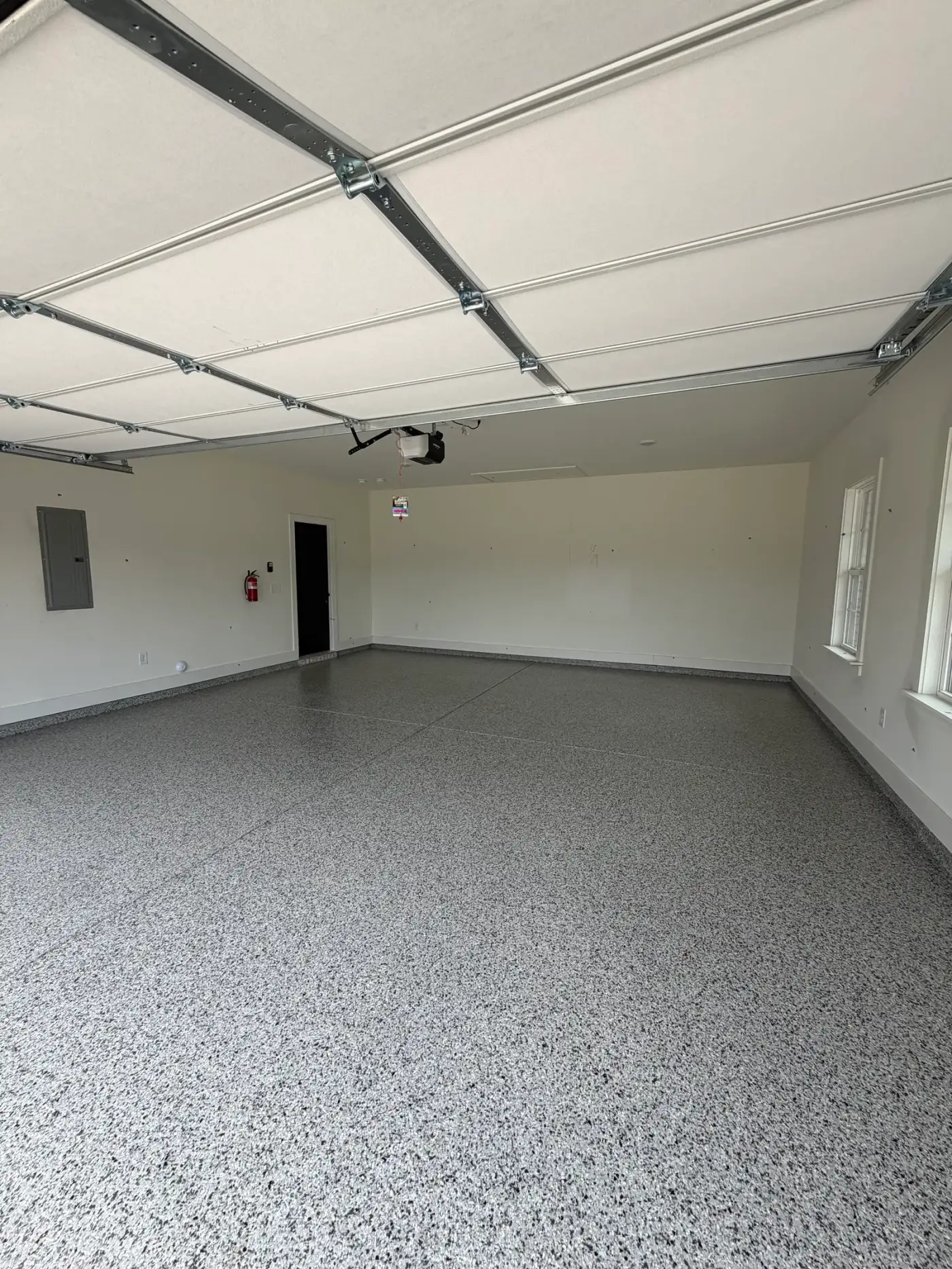 New-construction garage with a gray flake full-broadcast floor