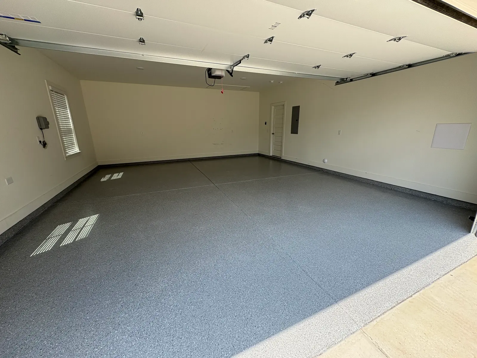Three-car garage with a charcoal flake-coated floor, freshly installed