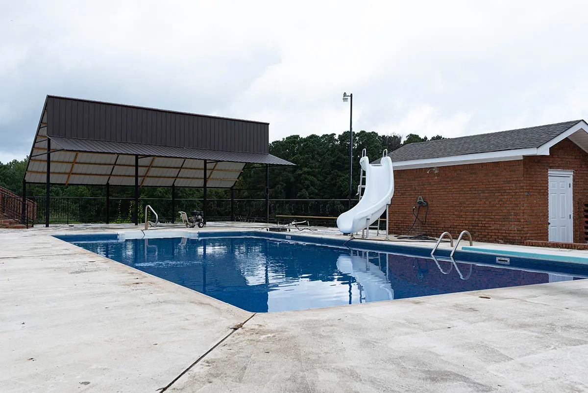 Commercial pool surrounded by worn bare concrete decking