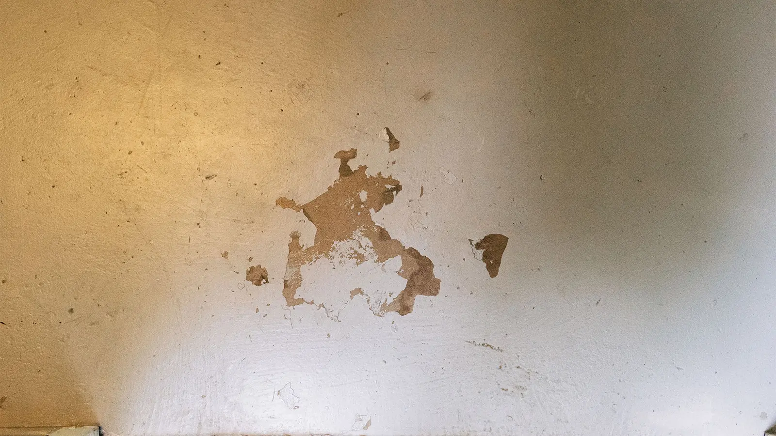 Concrete floor with a large spalled patch where the surface has broken away
